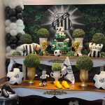 Mesa de festa infantil do Santos FC com bolo de futebol, escudo do clube, troféus e balões.