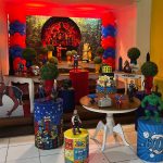 Vista lateral da decoração de aniversário dos Vingadores com personagens da Marvel, balões coloridos e mesas decoradas 2
