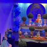 Mesa de aniversário da Cinderela com bolo decorado, painel da princesa e balões azuis.